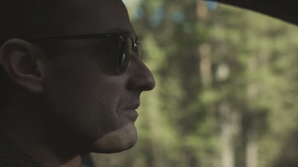 Mann fährt Auto auf der Straße, ernstes Gesicht aus nächster Nähe — Stockvideo