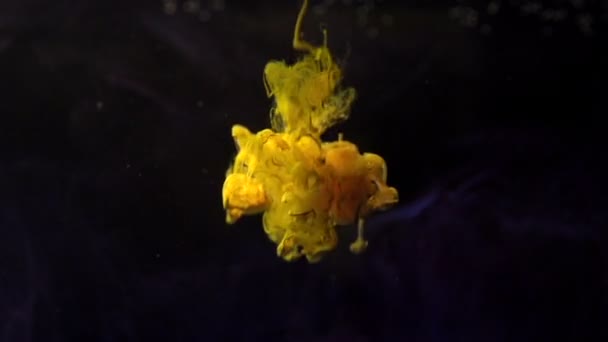 Tinta en agua cámara lenta color amarillo — Vídeo de stock