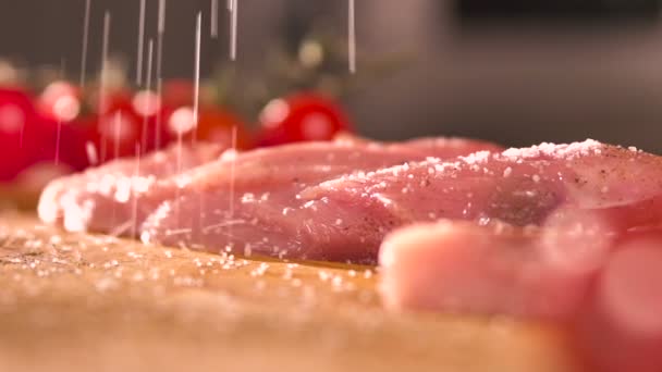 Zrnka soli spadnout na řízek masa closeup — Stock video