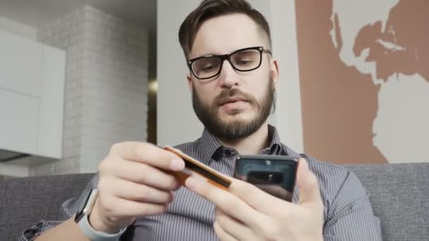 Homme achetant en ligne par smartphone carte bancaire de crédit — Video