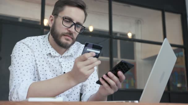 Hombre que paga en línea con tarjeta bancaria en el teléfono inteligente — Vídeos de Stock