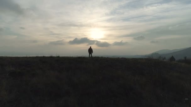 Un uomo escursionista a piedi sulla collina al lago al tramonto — Video Stock