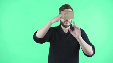 Yeşil arka plan üzerinde VR kulaklık kullanarak adam