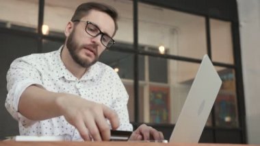 Online banka kartı ile dizüstü bilgisayar kullanan adam