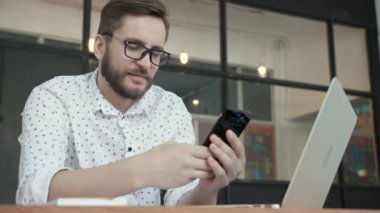 Adam gülümseme ve ofiste sohbet için telefon kullanma