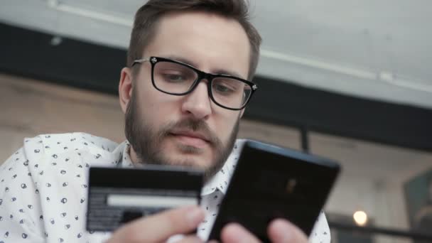 Homme faire le paiement en ligne par téléphone carte bancaire de crédit — Video