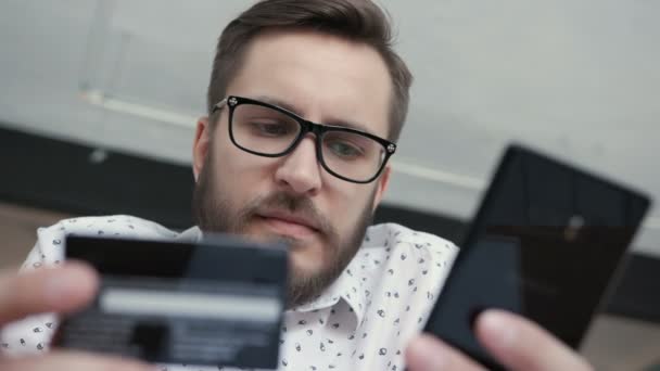 Homem usando banco on-line com telefone inteligente e cartão — Vídeo de Stock