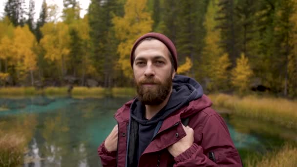 Портрет молодий усміхнений чоловік стоїть в лісі і насолоджується дикою природою крупним планом — стокове відео