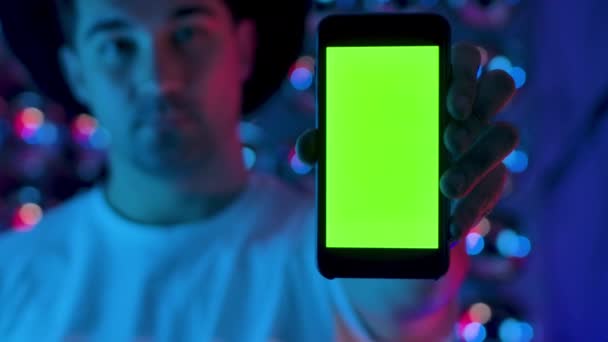 Kreative Männerhand hält ein Mobiltelefon mit vertikaler Green-Screen-Attrappe — Stockvideo