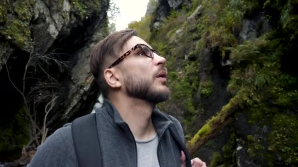Joven guapo mochila hombre buscando excitado en salvaje acantilado barranco vista panorámica — Vídeo de stock