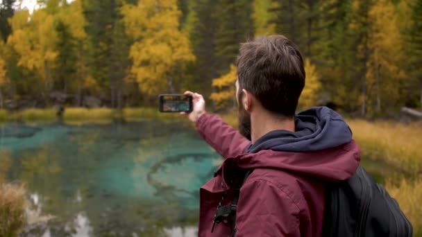 Moderne reisende Erwachsene mit einem Rucksack filmen die Natur mit dem Smartphone — Stockvideo