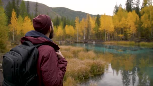 Πανοραμική άποψη του ενήλικα ταξιδιώτη Backpacker Αρσενικό απολαμβάνει γραφική θέα λίμνη — Αρχείο Βίντεο