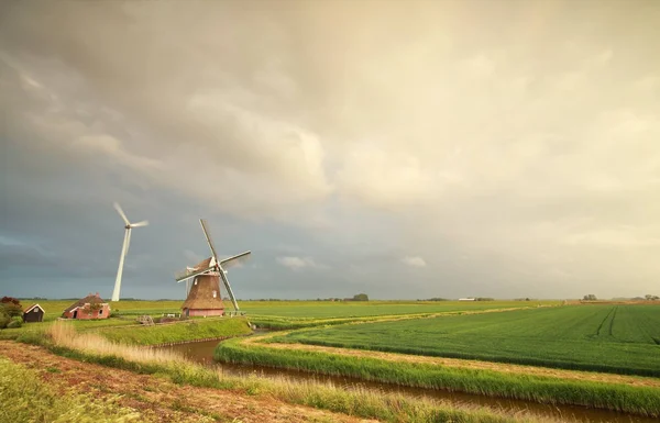 Neue und alte Windmühle bei regnerischem Himmel — Stockfoto