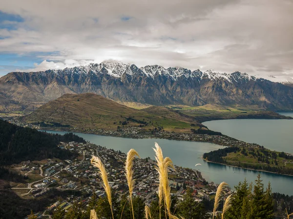 Snowy mountain range with a town and lake — Stock Photo, Image