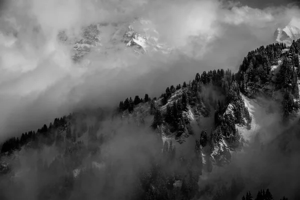 Gewitterwolken umgeben verschneite Berge in den Alpen — Stockfoto