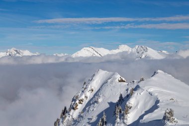 Kar ve bulutlar ve ağaçları ile kaplı dağları