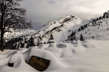 Bulutlar tarafından çevrili ve karla kaplı dağlar
