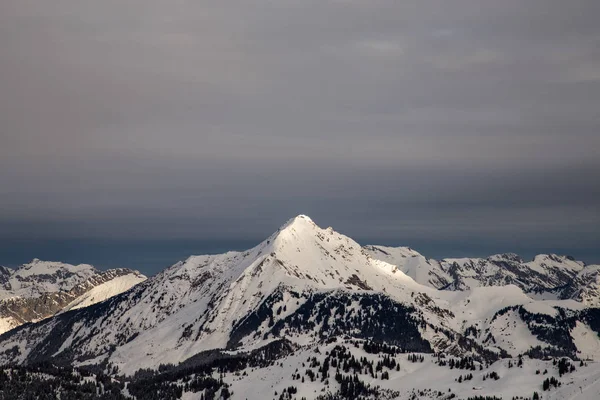 Montanhas cobertas de neve e rodeadas de nuvens — Fotografia de Stock