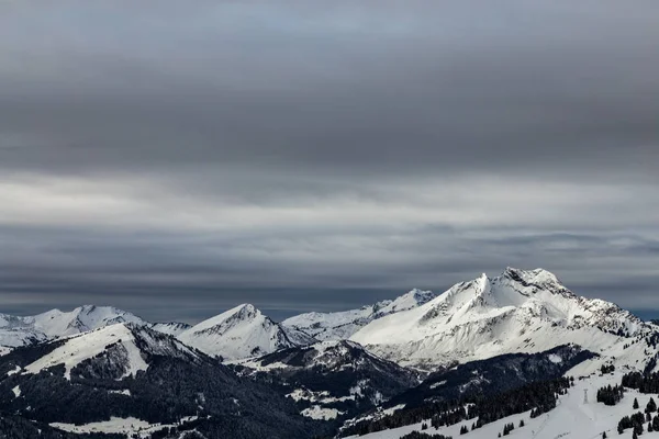 Гори вкриті снігом і оточені хмарами — стокове фото