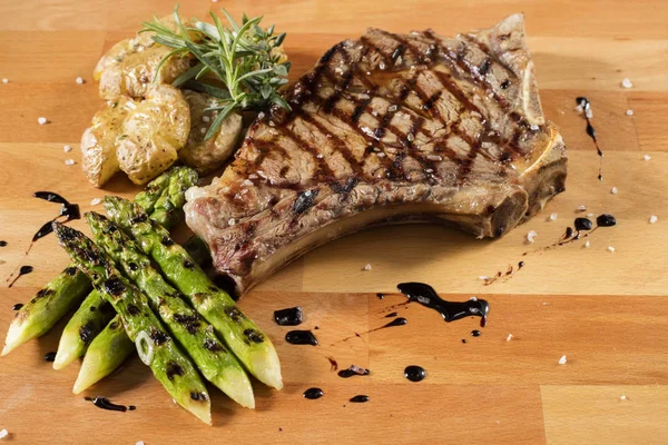 Bistecca di asparagi patate e funghi su tavola di legno — Foto Stock