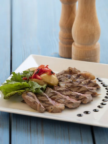 Steak Auf Teller Mit Kartoffeln Auf Blauem Hintergrund — Stockfoto