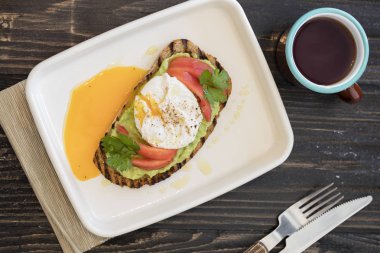 koyu arka plan üzerinde beyaz tabakta yumurta benedict