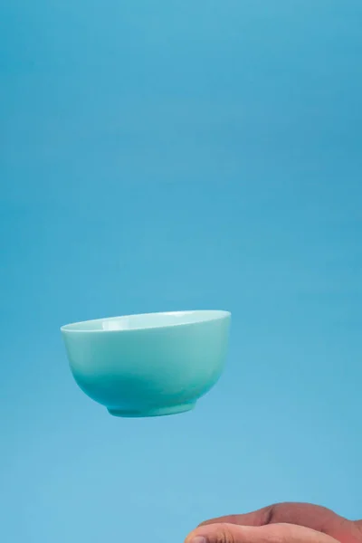 男性の下を飛ぶ朝食のための青いセラミック製の瓶の深いボウル — ストック写真