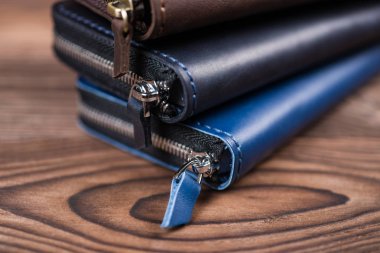 Ahşap, bulanık arka planda bir yığın el yapımı deri cüzdan. Görüntüyü kapat.