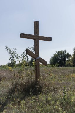 Tarlanın ortasında tahta bir haç. Hıristiyan sembolü.