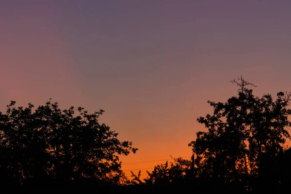 Pôr-do-sol da noite na aldeia a uma distância da cidade. O céu — Fotografia de Stock