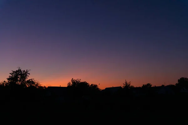 Puesta de sol por la noche en el pueblo a muy lejos de la ciudad. El cielo — Foto de Stock