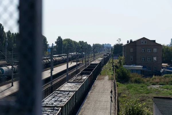 A train with freight cars full of garbage packs.