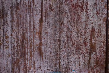 Eski kırmızı ahşap kapılı yüzey. Yakın plan. Yüzeyde rahatlama. Eski ahşap kapı desenli, çizikli tahtalar. Fotoğrafta kırmızı ve gri renkler.