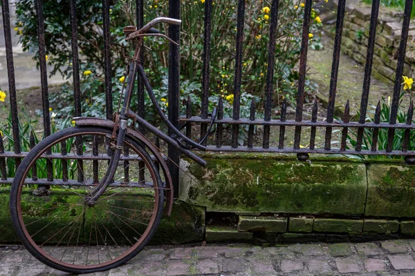 Meia bicicleta presa a uma grelha com uma corrente — Fotografia de Stock