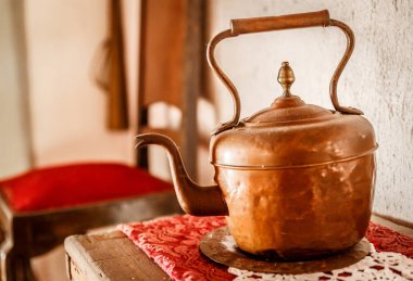 Eski bir ahşap masa üzerinde eski pirinç demlik