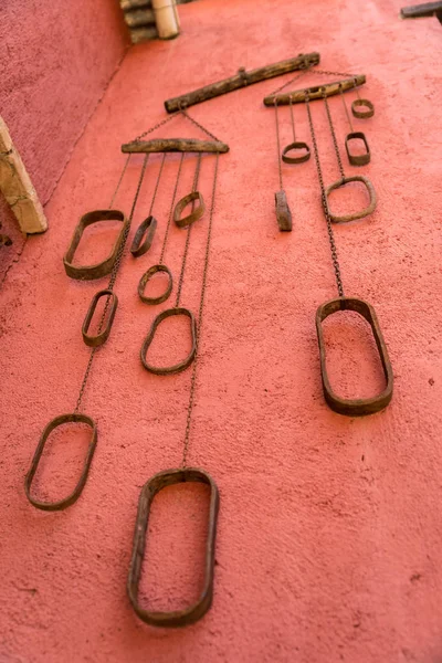 Conjunto de viejas cadenas metálicas colgadas en una pared roja — Foto de Stock