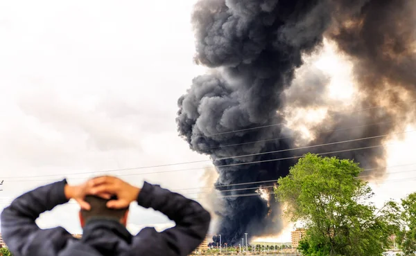 Een enorme rook verbaast een man een paar meter van een brand — Stockfoto
