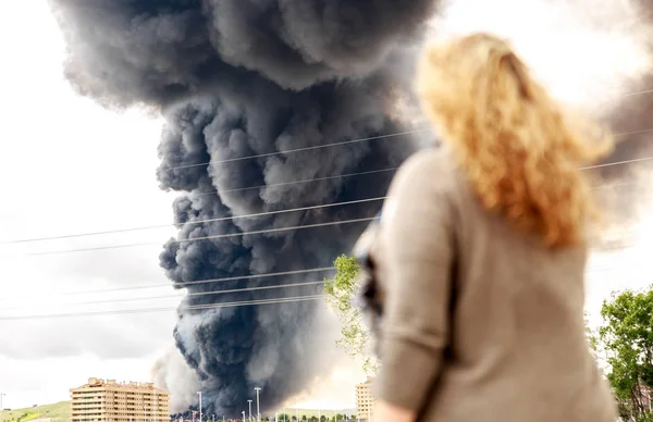 A dense and dark smoke from a fire in the middle of a population — Stock Photo, Image