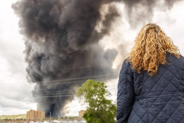 Blonďatá žena, která pozoruje velký oheň — Stock fotografie