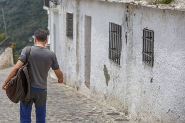 Bir turist, bir kasaba sokaklarında iner