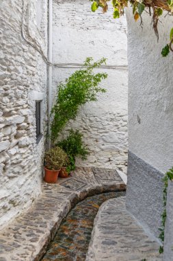 Eğri sokak ortasında bir köyde bir su kanalı ile 