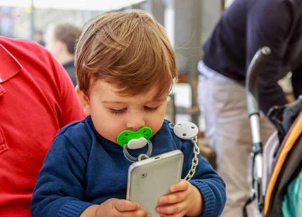 Beyaz bir cep telefonu ile sevimli bir çocuk