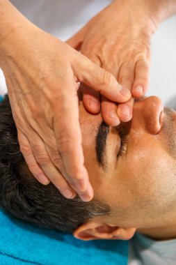 Bir terapist ince elleri yüzünde bir patien geçerlidir