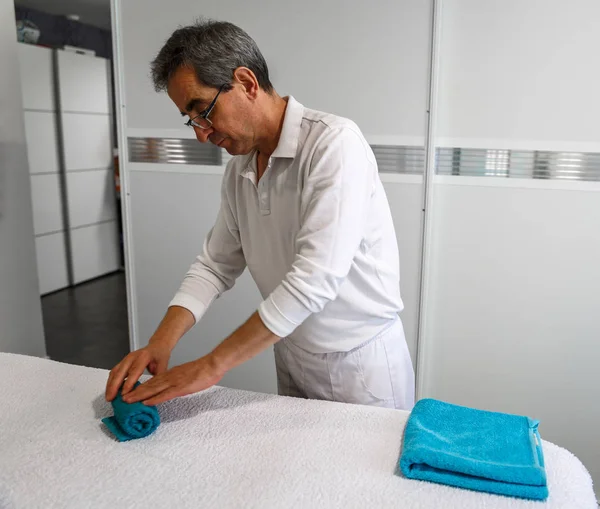 Olgun bir terapist havlu bir sedyeye alır.