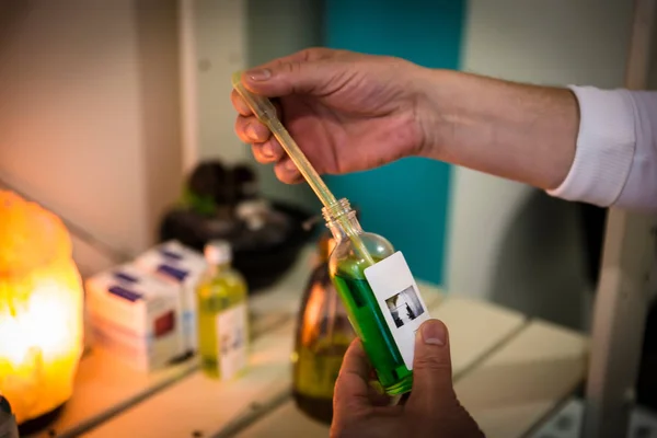 Een therapeut neemt een paar druppels met een pipet — Stockfoto