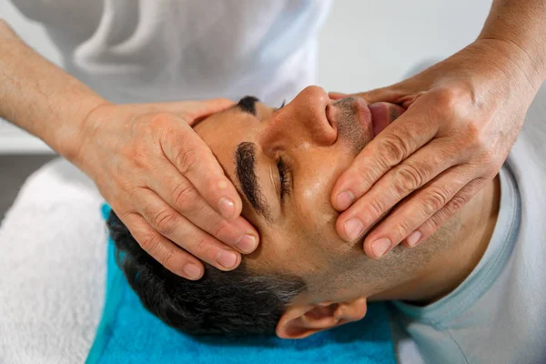 Bir terapist hastanın yüzünde elleriyle