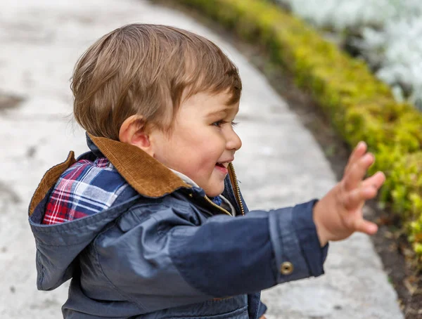 Un niño agradable saluda con su mano derecha — Foto de Stock
