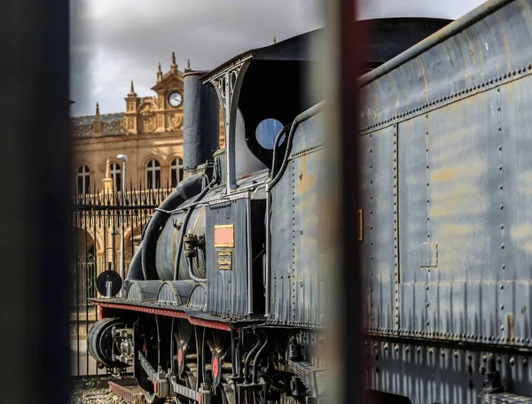 Locomotora de un tren de época junto a una antigua estación — Foto de Stock