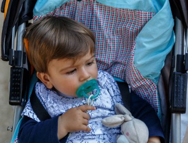 Bir emzik onun bebek arabası içinde olan bir çocuk
