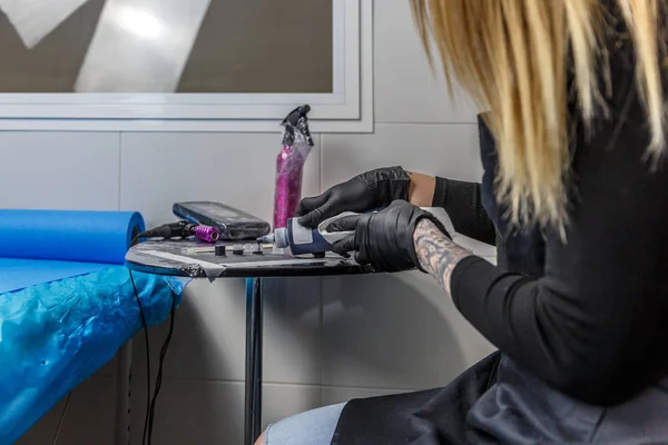 Een tattoo artiest vrouw bereidt de inkt te maken van een tatoeage — Stockfoto